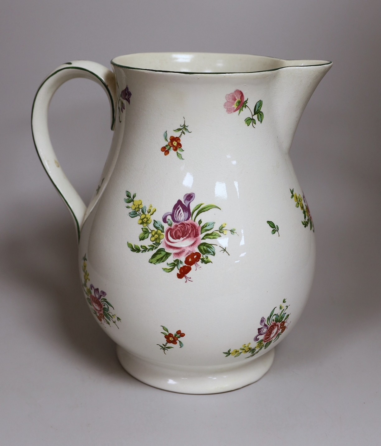 A Pountney jug, commemorating 100 years of the Bristol porcelain factory 1770 -1781, decorated with floral sprays and sprigs, green line border, 27cm high, printed mark. 26.5cm